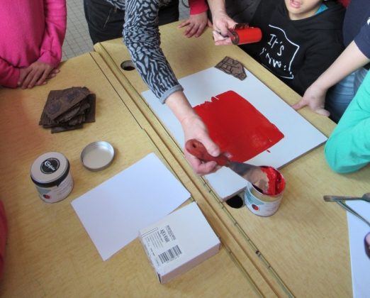 La gravure est recouverte de peinture avant d'être pressée contre une surface pour faire apparaître le motif