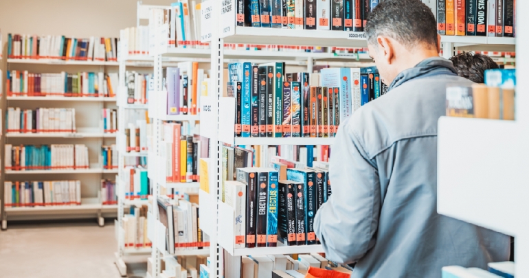 Un homme choisit des livres sur les étagères